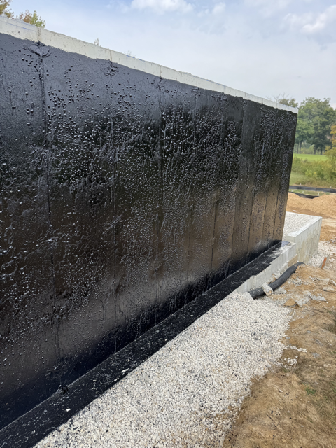 Tar coating applied to the basement walls for waterproofing.
