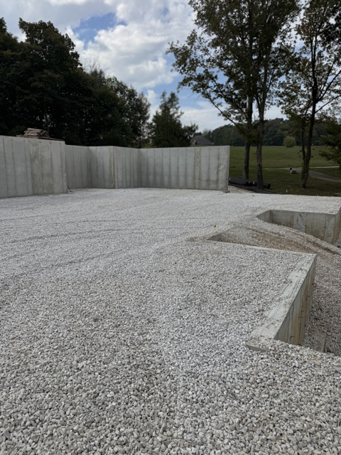 Concrete walls poured and basement filled in with rock.