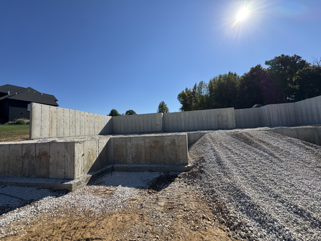 Concrete walls poured and basement filled in with rock.